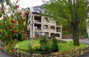 a stone house with a garden in front of it at Apartaments la Peguera in Bohí