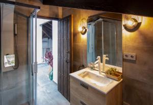 ein Bad mit einem Waschbecken und einem Spiegel in der Unterkunft La Casa Gris Boutique Home in Benissa