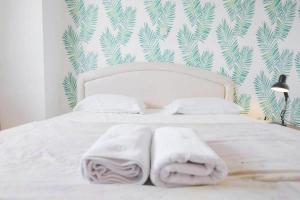 - une chambre avec un lit blanc et des serviettes dans l'établissement Apartemen Sentra Timur Residence - Cheap Inn Tower Orange, à Jakarta