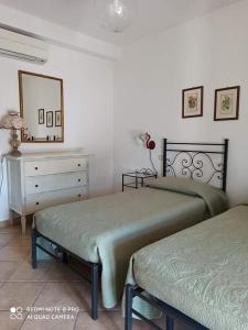 a bedroom with two beds and a dresser and a mirror at Agriturismo Oasi del Pianettino in Campagnatico