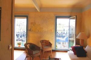 een woonkamer met 2 stoelen en 2 grote ramen bij vue exceptionnelle sur les canaux in Sète