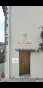 budynek z drewnianymi drzwiami i znakiem na nim w obiekcie B&B la casa di fuori porta w mieście Gricignano