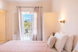 1 dormitorio con 1 cama y puerta a un balcón en Albatross Apartments by Konnect, Ipsos Corfu, en Ýpsos