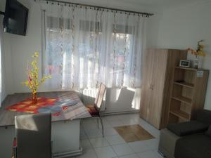 uma sala de estar com uma mesa, uma cadeira e uma janela em Füge Vendégház em Miskolctapolca