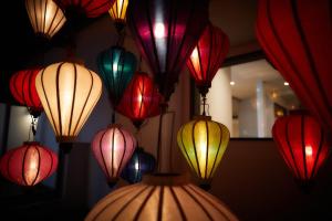 a group of colorful lanterns hanging on a wall at ADAN RESORT 灯 - Lamp - in Motobu