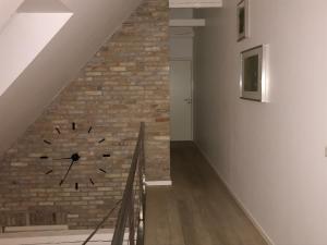 una pared de ladrillo con un reloj en una escalera en Rum og rooms, en Brundby