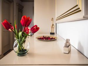 a vase with red flowers on a kitchen counter at Sky Park Home in Iaşi