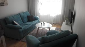 sala de estar con sofá azul y mesa en Powstańców Wielkopolskich 12, en Poznan