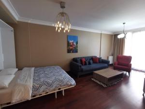 1 dormitorio con cama, sofá y lámpara de araña en CTS Elysium Residence Taksim, en Estambul
