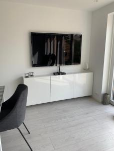 a white living room with a television on a white wall at Årostunet 3 in Søgne