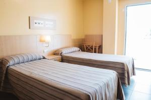 pokój hotelowy z dwoma łóżkami i stołem w obiekcie Apartamentos Turisticos Terralta w mieście Benidorm