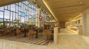 un ristorante con tavoli, sedie e finestre di Lemon Tree Premier, Bhubaneswar a Bhubaneshwar