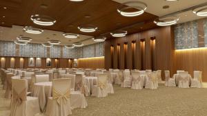 un salón de banquetes con mesas blancas y sillas en Lemon Tree Premier, Bhubaneswar, en Bhubaneshwar