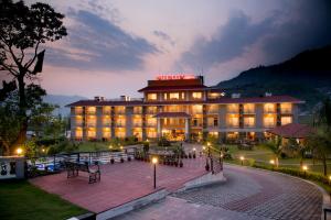a hotel with a lit up building at night at Waterfront Resort by KGH Group in Pokhara