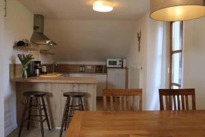 a kitchen with a table and some bar stools at Ferienwohnung Teufelsbauer in Rimbach