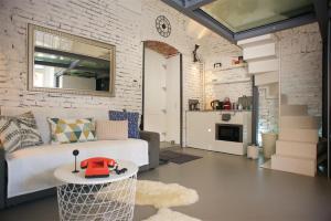 a living room with a white brick wall at Micro Loft Central in Unirii in Cluj-Napoca