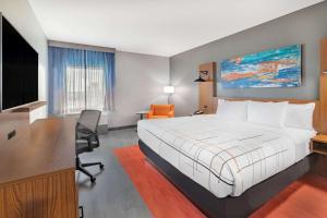 フォート・ストックトンにあるLa Quinta Inn & Suites by Wyndham Fort Stockton Northeastの大きなベッドとデスクが備わるホテルルームです。