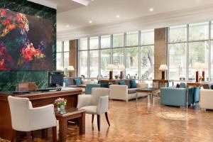 a lobby with chairs and a large painting on the wall at Wyndham Tashkent in Tashkent