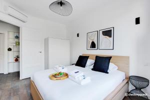 una camera da letto bianca con un letto e asciugamani di CMG - Place des Vosges a Parigi