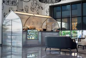 a lobby with a chair and a counter with food at The First Collection Dubai Marina in Dubai