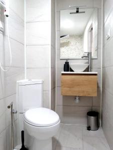 Baño blanco con aseo y lavamanos en Piso De Balboa Wi-Fi, Air-Con en Gandía