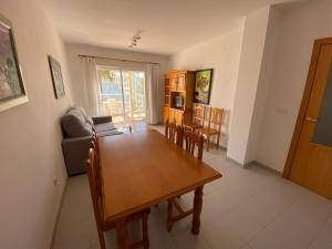 a dining room and living room with a table and chairs at Apartamentos Serenamar Altamar in Alcossebre