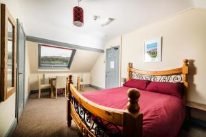 a bedroom with a bed, chair and a window at Llangollen Hostel in Llangollen