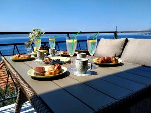 a table with plates of food and drinks on it at Apartments Asija in Brela