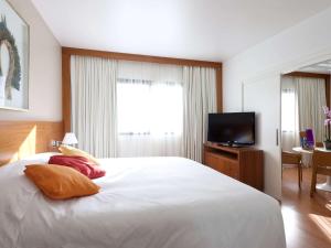 سرير أو أسرّة في غرفة في Novotel Campo Grande