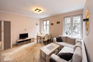 a living room with a couch and a table at Gdańskie Apartamenty - Old Town Rooms & Apartments in Gdańsk