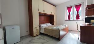 a small bedroom with a bed and a window at Alepou Guest House in Gasperina