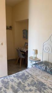 una camera da letto con un letto e un tavolo con una sedia di agriturismo la selva a Finale Ligure