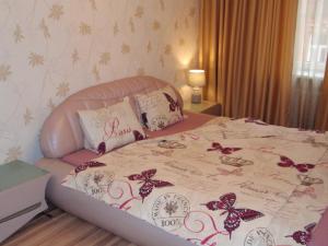 1 dormitorio con cama con colcha de mariposas. en Central Cietokšņa Street Apartment, en Daugavpils