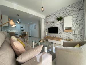 un soggiorno con divano e TV di Bianca Beach 212 - cosy flat 250m from Mil Palmeras beach a La Horadada