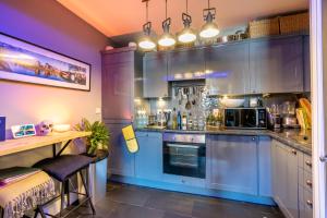 uma grande cozinha com armários azuis e uma mesa em Quayside em York