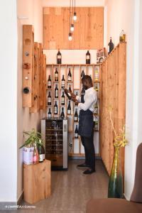 un homme se tient debout dans une salle de dégustation de vin dans l'établissement L'imprévu, à Cotonou