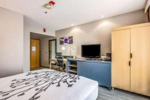 a hotel room with a bed and a desk with a television at Sleep Inn Fort Mill near Carowinds Blvd in Fort Mill