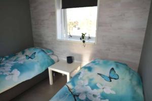 a bedroom with a bed and a table and a window at Lamsoor in Serooskerke