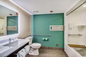a bathroom with a toilet and a sink at Clarion Pointe Wake Forest – Raleigh North in Wake Forest