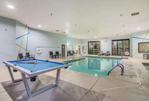 una piscina cubierta con mesa de ping pong en una habitación en Clarion Pointe Wake Forest – Raleigh North, en Wake Forest