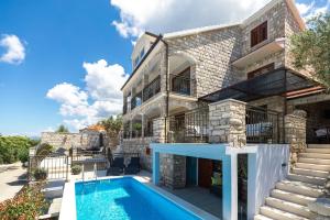 a house with a swimming pool in front of it at Holiday Home Dona Maria in Prigradica