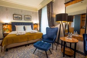 カトヴィツェにあるホテル ディアメント カトーウィツェのベッド、テーブル、椅子が備わるホテルルームです。