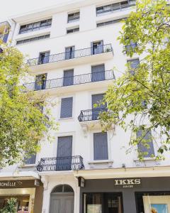 a white building with balconies on top of it at Résidence Le Marly in Annemasse