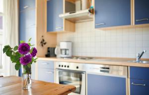 um vaso de flores roxas sentado numa mesa numa cozinha em Sonneneck Rerik em Rerik