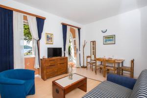 a living room with a couch and a tv and a table at Apartments Vidak in Molunat