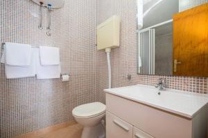 a bathroom with a toilet and a sink and a mirror at Apartments Vidak in Molunat