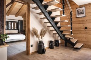 a wooden staircase in a room with a bedroom at Spacieux duplex avec vue in La Clusaz