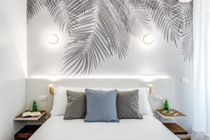 sypialnia z łóżkiem z malowidłem palmowym na ścianie w obiekcie Victor Boutique Hotel w Mediolanie