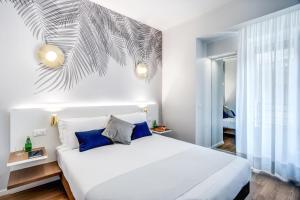 a bedroom with a white bed and white walls at Victor Boutique Hotel in Milan