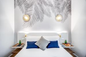 a bedroom with a white bed with blue pillows at Victor Boutique Hotel in Milan